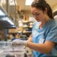 healthcare worker labeling medical specimen containers in a laboratory