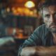 man struggling with depression and alcohol use disorder, isolated with a whiskey bottle