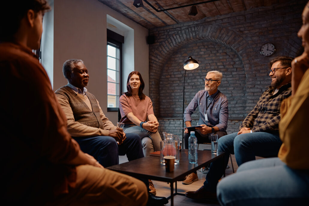 Drug Counseling in New Jersey: Recovery Support 1 drug counseling participants and their counselor communicating while sitting in a circle at mental health center.